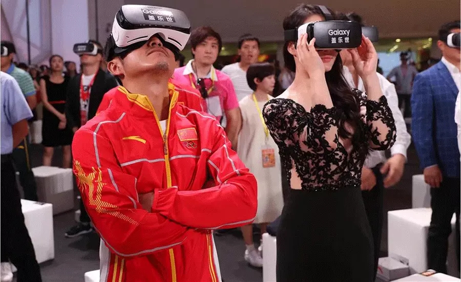 图为邹市明用VR技术观看观看冠军龙服发布视频